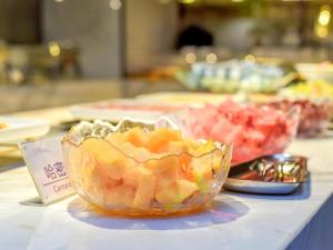einen Tisch mit einer Schale Obst auf einem Tisch in der Unterkunft Lavande Hotel Nanchong Xihua Shida in Nanchong