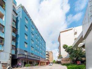 niebieski budynek po stronie ulicy w obiekcie Lavande Hotel Zhongshan Shiqi Daxinxinduhui North Zhongshan Station w mieście Zhongshan