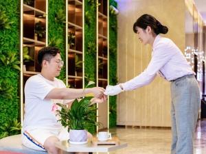 a woman shaking the hand of a man at Lavande Hotel Bayannaoer City Hall Siji Huacheng in Bayannur