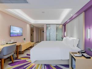 ein Hotelzimmer mit einem großen Bett und einem Schreibtisch in der Unterkunft Lavande Hotel Shenzhen Bay Houhai Avenue in Shenzhen
