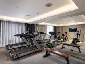 a gym with several tread machines and a mirror at Lavande Hotel Wuhan 2nd Guanggu Road in Liufangling