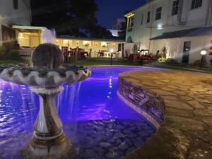 a fountain in front of a house at night at Selborne Hotel in Bulawayo