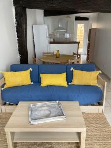 a blue couch with yellow pillows in a living room at Superbe T3 dans le quartier historique de Marmande in Marmande