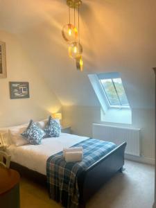 1 dormitorio con cama con almohadas y ventana en Luxury Country Bolthole Near Soho Farmhouse, en Middle Barton