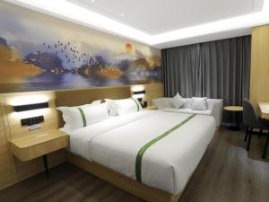 a bedroom with a large white bed in a room at Green Tree Inn Hebei Cangzhou Hejian Middle Shijing Road in Xiguan