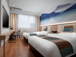 Cette chambre comprend 2 lits et une télévision. dans l'établissement VX Hotel Beijing Daxing Wufutang Metro Station Zhongke Dianshanggu, à Donggaodi