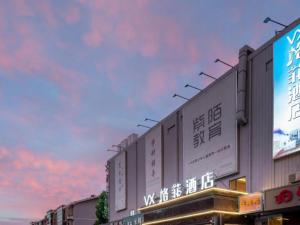 VX Hotel Beijing Daxing Wufutang Metro Station Zhongke Dianshanggu في Donggaodi: مبنى مكتوب بجانبه