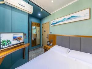 蘭州市にあるFERONIA Hotel Gansu Lanzhou Chengguan District Gannan Roadのベッドルーム(ベッド1台、薄型テレビ付)
