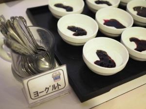 a tray with bowls of food and spoons on it at Omura Yasuda Ocean Hotel in Imazugō