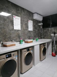 eine Küche mit zwei Waschmaschinen und einer Theke in der Unterkunft Borrman Hotel Liuzhou Liujing District Government in Liuzhou