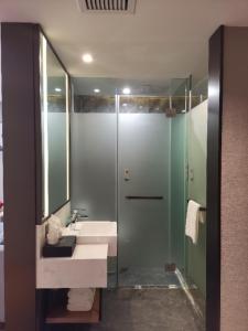 ein Bad mit einem Waschbecken und einer Dusche in der Unterkunft Borrman Hotel Liuzhou Liujing District Government in Liuzhou