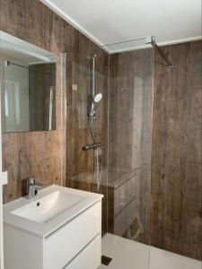 een badkamer met een witte wastafel en een douche bij Vakantiepark de Boomgaard in Westkapelle
