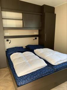 2 almohadas blancas en una cama en una habitación en Vakantiepark de Boomgaard, en Westkapelle