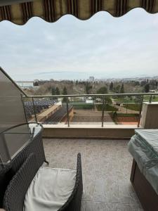 a balcony with two chairs and a view of a stadium at Апартамент Градски Парк in Dobrich