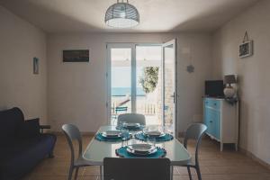 a dining room with a table and chairs and a window at Tabarano Holiday Apartment by Diddoi in Torre Suda