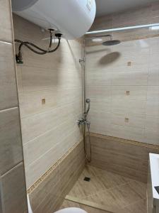 a shower stall in a bathroom with a toilet at Апартамент Градски Парк in Dobrich +3 photos