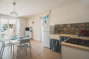 a kitchen with a table and a kitchen with a dining room at Tabarano Holiday Apartment by Diddoi in Torre Suda