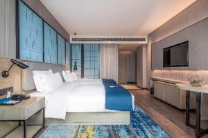 a hotel room with a bed and a television at Echarm Hotel Torch Development Zone Zhongshan Station in Zhongshan