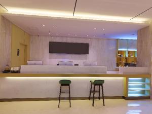 un vestíbulo con un bar con dos taburetes en City Comfort Inn Golmud City Hall Yanhu Square en Golmud