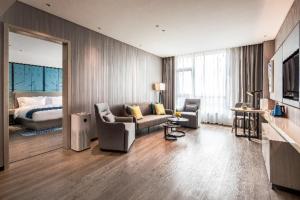 a living room with a couch and a bed at Echarm Hotel Torch Development Zone Zhongshan Station in Zhongshan