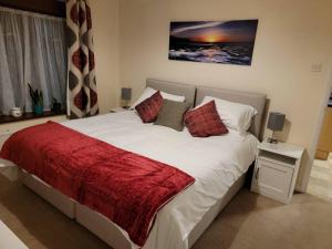 a bedroom with a large bed with a red blanket at Hidden Gem in Eastbourne