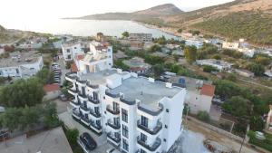 widok z powietrza na duży biały budynek nad oceanem w obiekcie GL Hotel Ksamil w mieście Ksamil