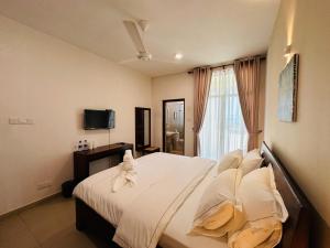 a bedroom with a bed with white sheets and a window at Moi Hikka by DBI in Hikkaduwa