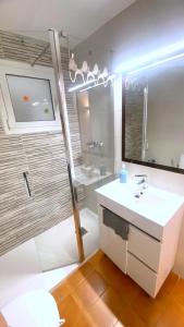 een badkamer met een witte wastafel en een spiegel bij Dallas 1 c in Roses