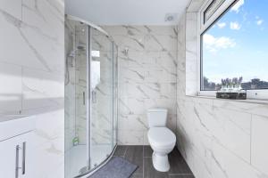 uma casa de banho com um WC e uma cabina de duche em vidro. em Serviced Ensuite Modern Studio - Sleeps 2 - Near Wembley Stadium - Good Transport Link to Central London - Harrow HA3 em Hatch End