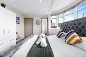 a bedroom with a large bed with towels on it at Serviced Ensuite Modern Studio - Sleeps 2 - Near Wembley Stadium - Good Transport Link to Central London - Harrow HA3 in Hatch End