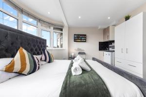 um quarto com uma grande cama branca e uma cabeceira preta em Serviced Ensuite Modern Studio - Sleeps 2 - Near Wembley Stadium - Good Transport Link to Central London - Harrow HA3 em Hatch End