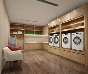 a laundry room with three washing machines and a chair at Echeng Hotel Shenzhen Tian'an Cloud Valley Huawei Base in Tiantangwei