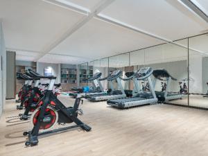 a gym with a row of tread machines in a room at Echeng Hotel Shenzhen Tian'an Cloud Valley Huawei Base in Tiantangwei