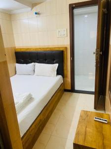 a bedroom with a bed and a door with a table at Hotel BH residency in Mumbai