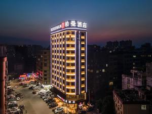 un bâtiment éclairé dans une ville la nuit dans l'établissement Borrman Hotel Wuzhou Teng County, à Tengcheng