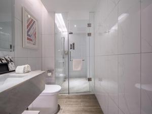 a bathroom with a shower and a toilet and a sink at Borrman Hotel Wuzhou Teng County in Tengcheng