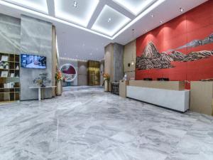 a lobby with a large marble floor and red walls at Poltton International Service Apartment Jieyang Qiaonan Yudu in Jieyang