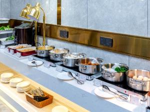 a buffet line with pots and pans of food at Poltton International Service Apartment Jieyang Qiaonan Yudu in Jieyang