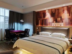 a bedroom with a large bed and a table and chairs at City Comfort Inn Yidu Three Gorges Qianguqing Wanda Plaza in Yidu