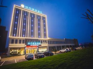 a large building with cars parked in a parking lot at City Comfort Inn Yidu Three Gorges Qianguqing Wanda Plaza in Yidu