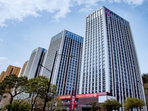 a tall building with many windows in a city at Echarm Hotel Shiyan Beijing South Road Hanjiang Normal College in Shiyan