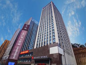 a tall building with a sign in front of it at Echarm Hotel Shiyan Beijing South Road Hanjiang Normal College in Shiyan