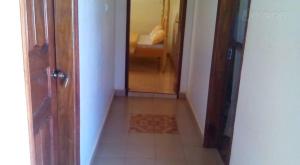 an empty hallway with an open door and a room at Trinity Guest House in Jinja