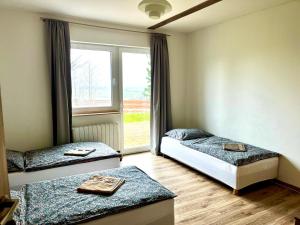 una habitación con dos camas y una ventana en Siedlisko Wierchy, en Wieściszowice