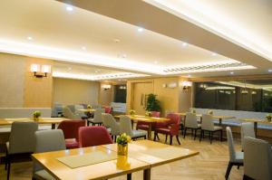 a dining room with tables and chairs and tablesktop at Echeng Hotel Enshi Minzu Road in Enshi