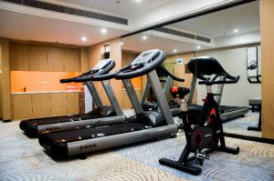 einen Fitnessraum mit mehreren Laufbändern in einem Zimmer in der Unterkunft Echeng Hotel Enshi Minzu Road in Enshi