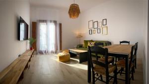 a living room with a table and a green couch at Boutique Casa Caldereros in Córdoba