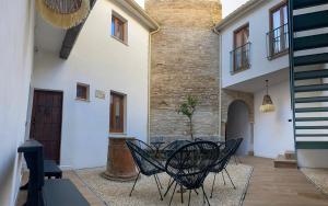 a patio with chairs and a table in a building at Boutique Casa Caldereros in Córdoba