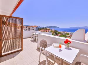 a balcony with a table and chairs and the ocean at Yoga House Kaş in Kaş