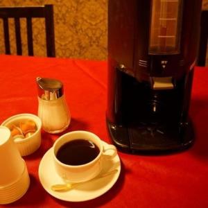 a cup of coffee on a red table with a coffee maker at Hotel Miyoshino Annex in Sano